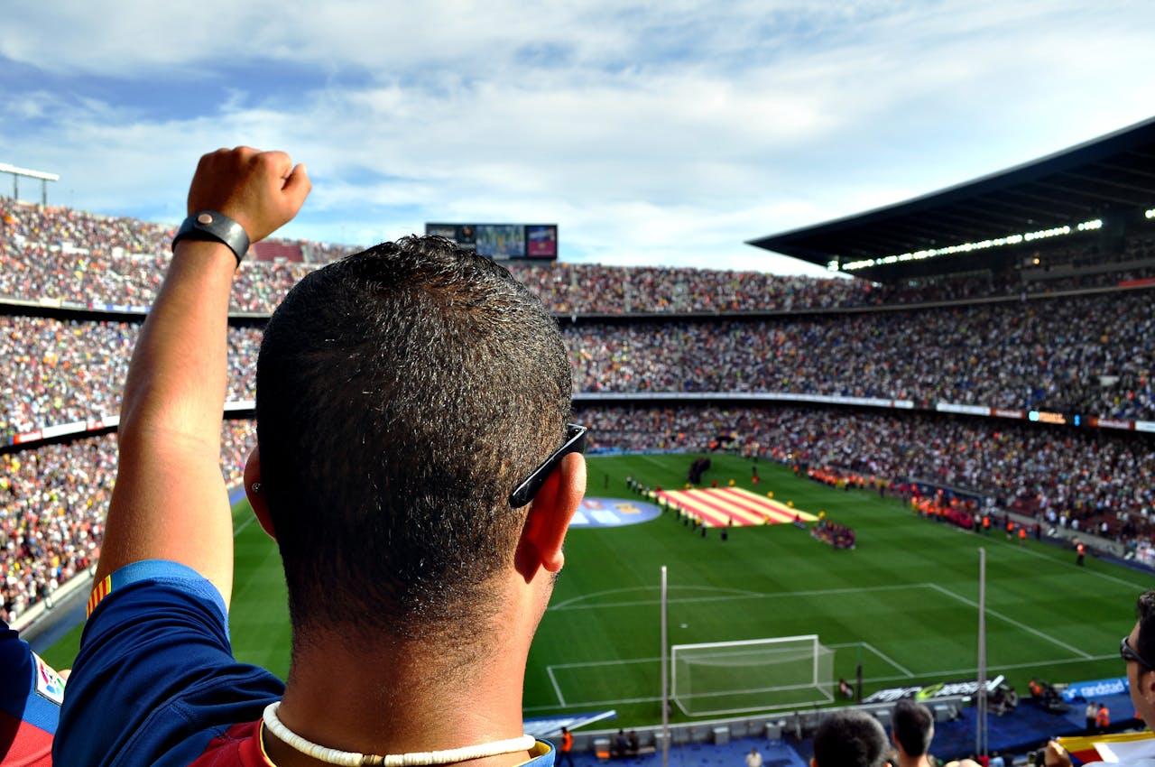 creative-01 A passionate football fan cheers among a crowd at a bustling stadium, creating an electrifying atmosphere.