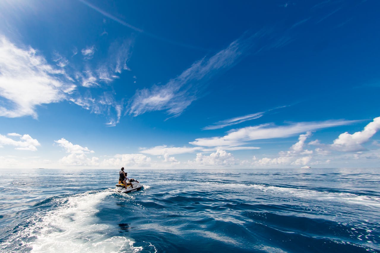 creative-03 A thrilling jet ski ride on the open ocean beneath bright blue skies, perfect for adventure seekers.