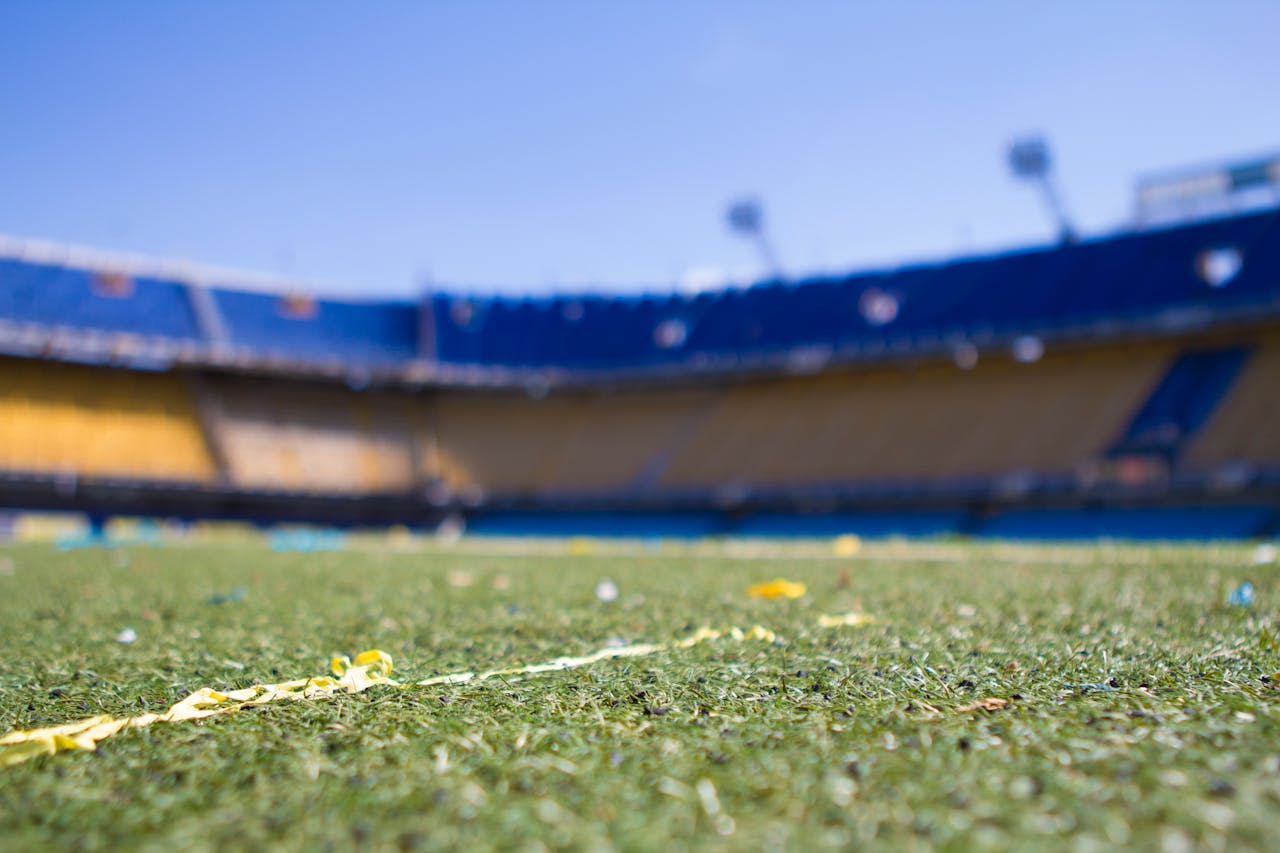 brand-03 Close-up view of a vibrant football pitch in a sunlit Buenos Aires stadium, perfect for sports enthusiasts.